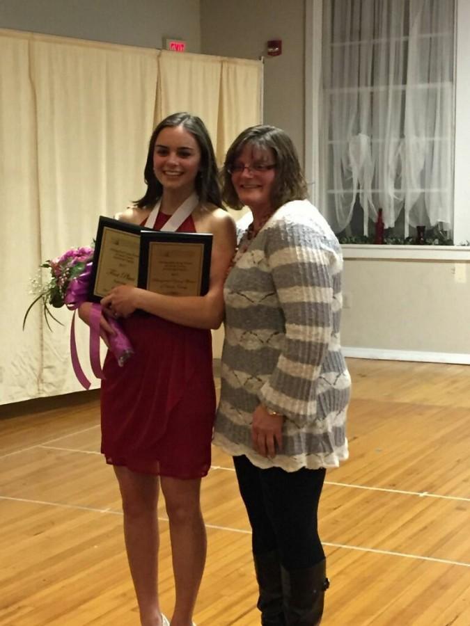 Madison Stanley (17) standing with her mother and showing the awards she won from the regional competition.