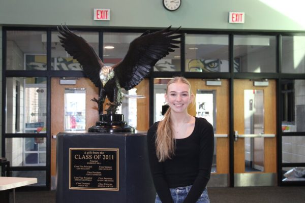 Emily stands at the front of the building, next to the eagle statue.