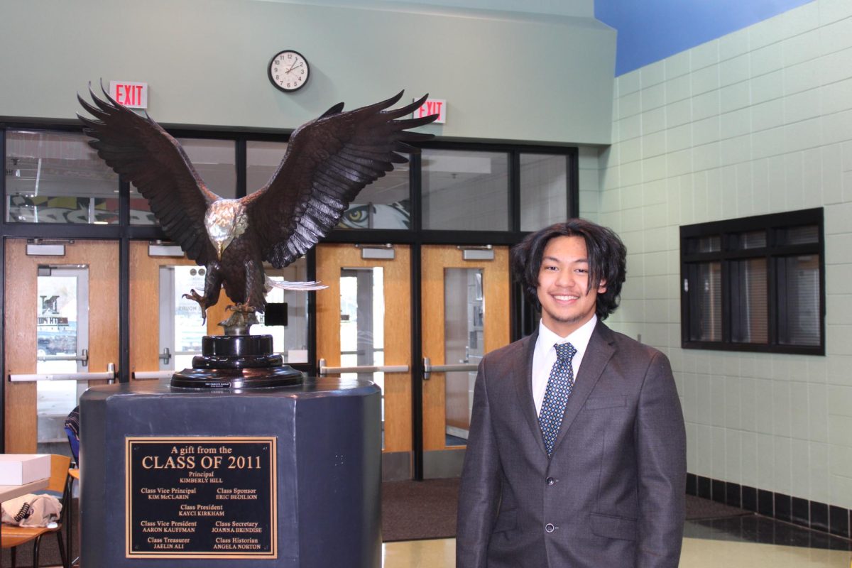 Francis stands professionally with the eagle statue.