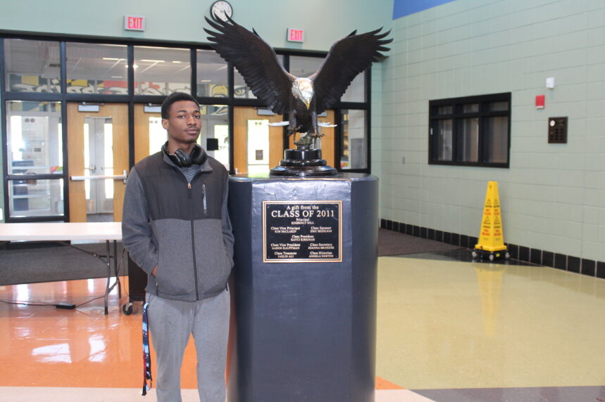 Raymond stands confidently with the Eagle in the lobby.